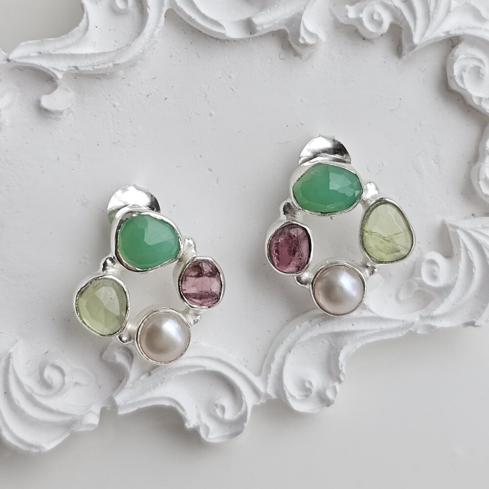 Vienetiniai sidabriniai auskarai prie ausies.